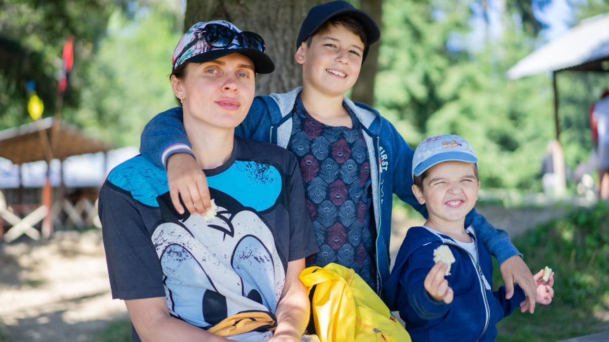 Mother with her two sons having fun outdoors, enjoying a sunny day.
